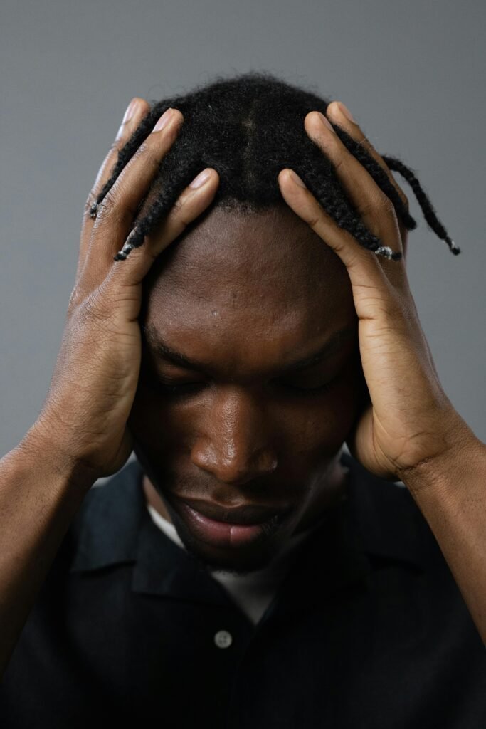 رجل يمسك رأسه بتوتر يعكس ارتباط العقل بالجسد وتأثير الضغط النفسي على الألم الجسدي