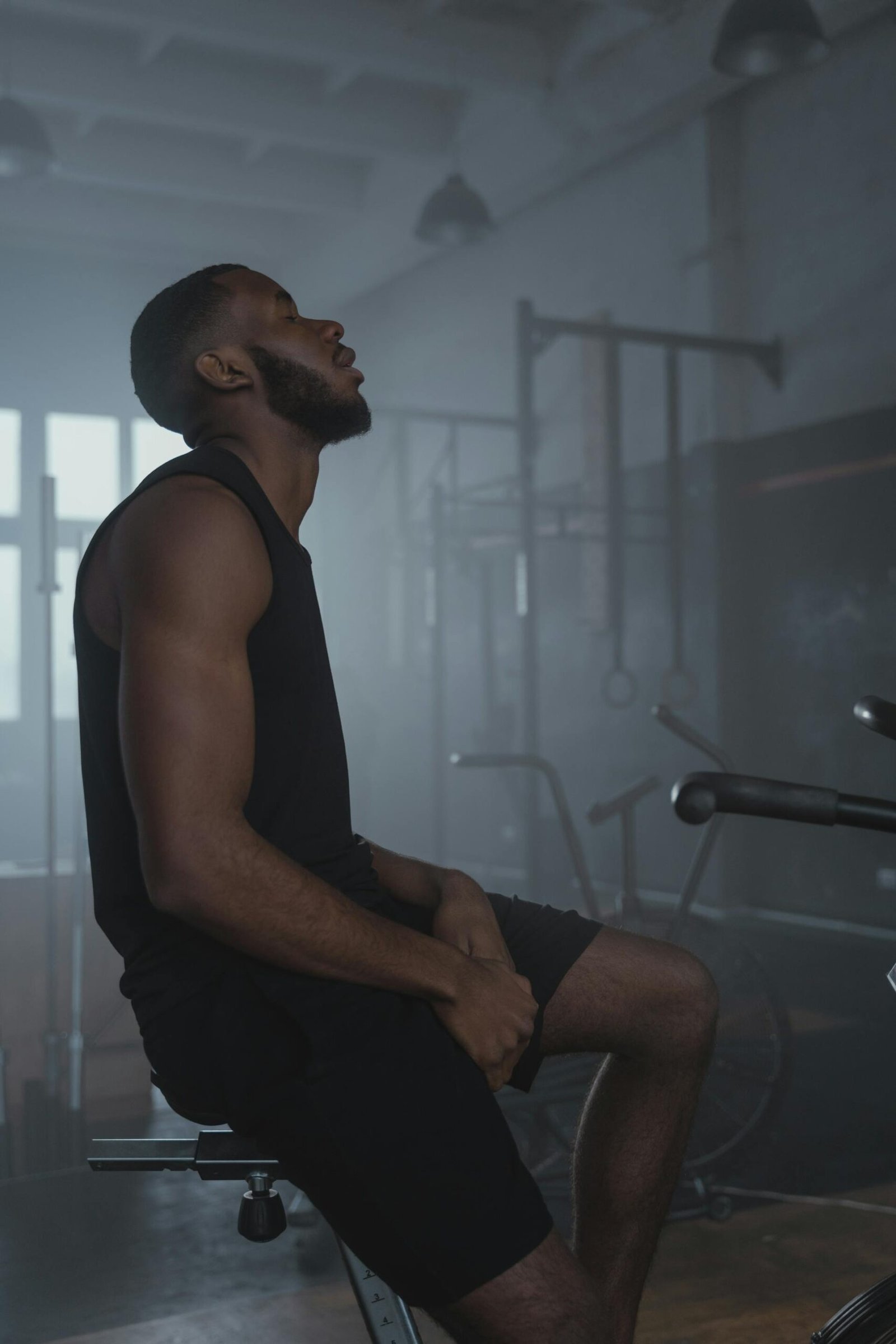 رياضي يجلس مرهقًا في النادي بعد تمرين بدون نتائج